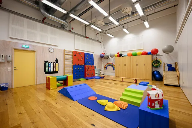 Stor gymsal med klatrevegg, skap og variert treningsutstyr