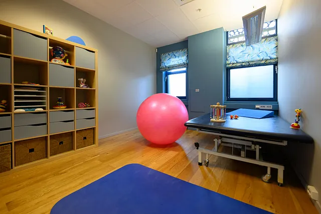 Trenings- og lekerom med stor treningsball, oppbevaringshyller og matte