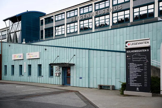 Inngangsparti til Bergen Helsehus med oversiktsskilt og parkeringsplasser
